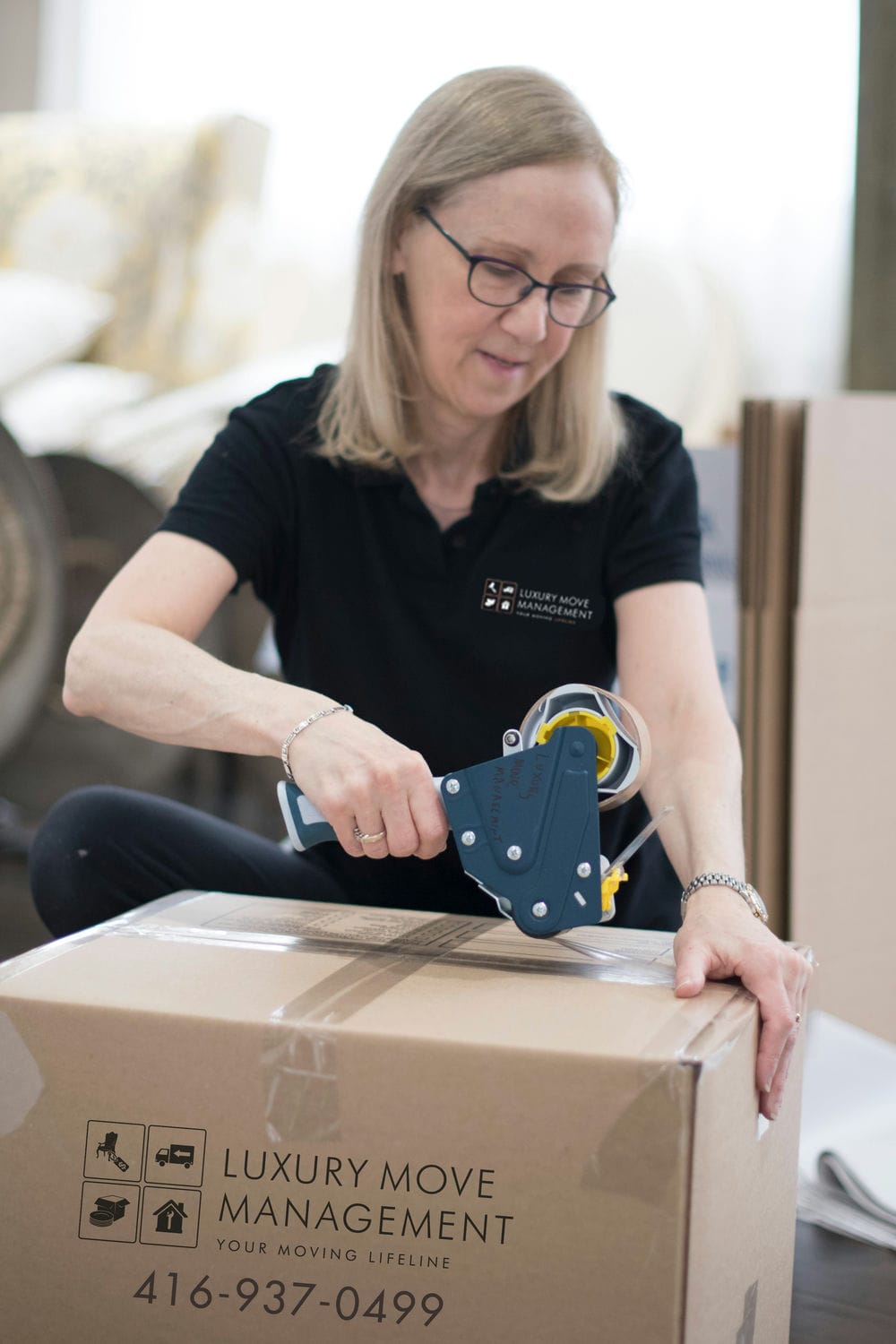 mover using tape gun to pack up a box