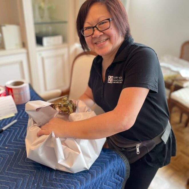 lady carefully packing up items for move